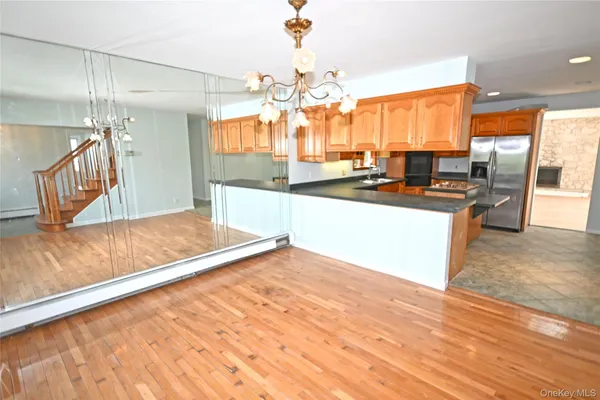 a view of a kitchen with kitchen island a sink wooden floor and a counter top space