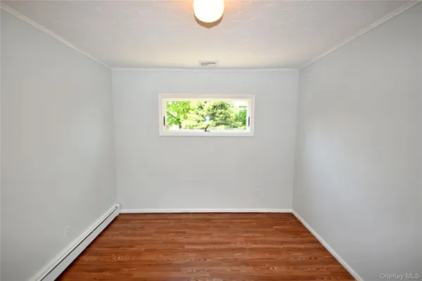 a view of room with window and wooden floor