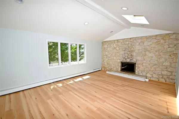 an empty room with windows and fireplace