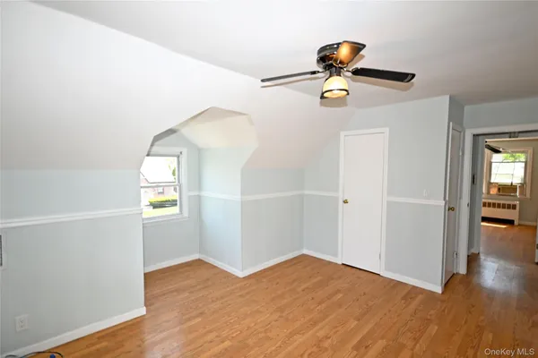 a view of empty room with wooden floor and windows
