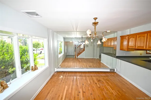 a view of a living room with kitchen area and wooden floor