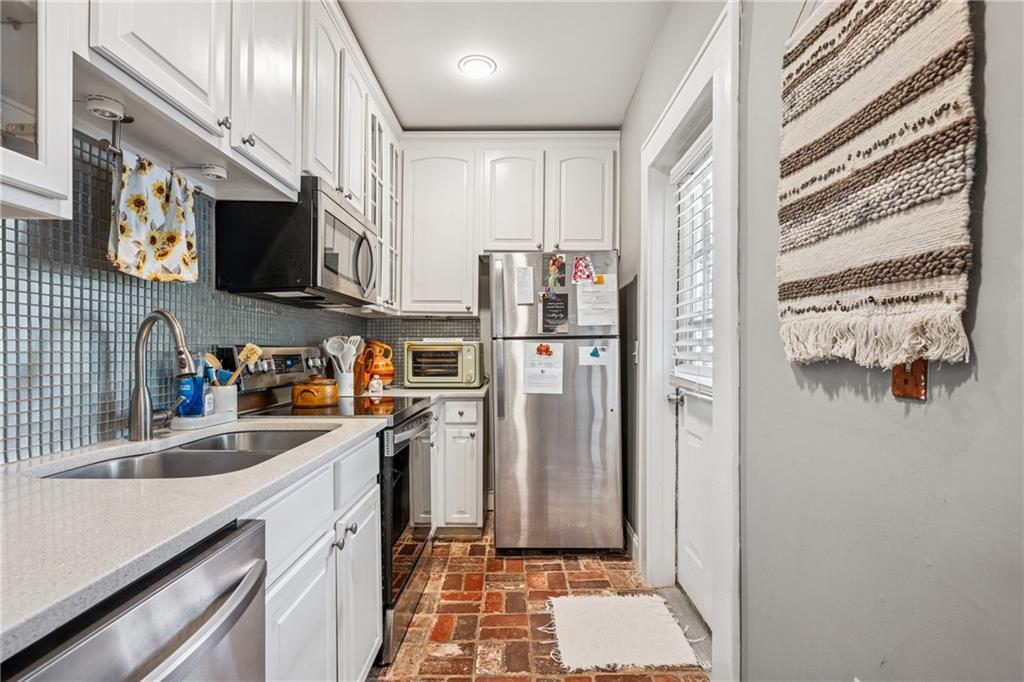 737 Barnett Street Northeast, Unit C4 Atlanta, GA 30306 - Photo 5 of 24 a kitchen with stainless steel appliances a refrigerator a sink a stove and cabinets