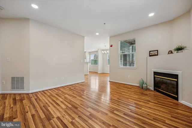 a kitchen with stainless steel appliances granite countertop a refrigerator a sink dishwasher and a oven with wooden floor