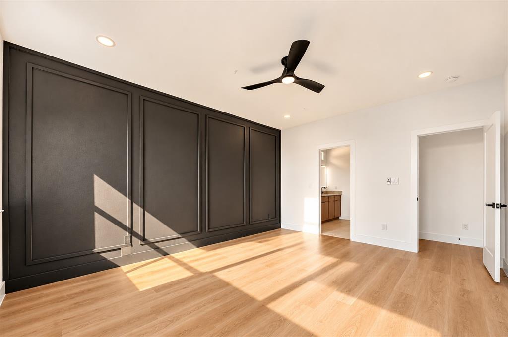1632 West Wintergreen Road Lancaster, TX 75134 - Photo 13 of 30 Accent wall with panel molding, recessed lighting, ceiling fan, wood-finish flooring, and white interior doors