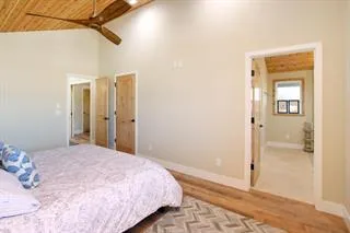 a bedroom with a bed and a glass door shower