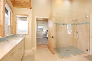 a bathroom with a granite countertop sink a mirror and a shower