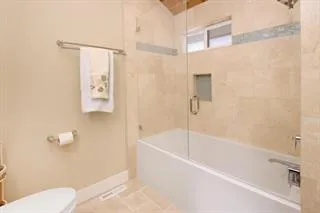 a white bath tub sitting next to a white toilet