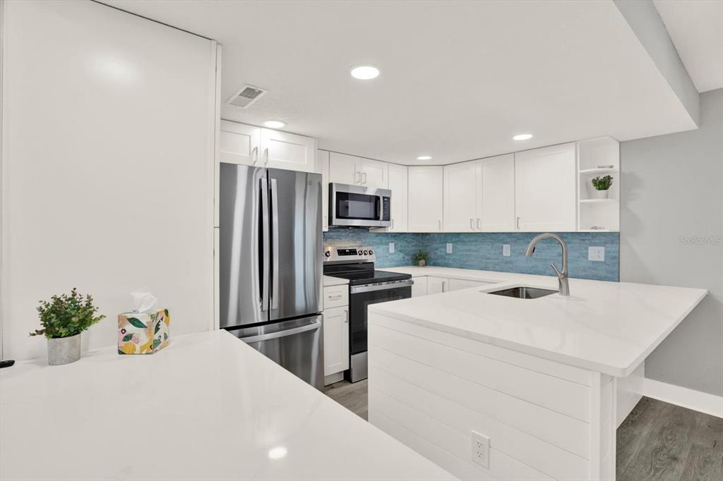 337 Rex Place, Unit A Madeira Beach, FL 33708 - Photo 12 of 48 a kitchen with a sink a stove and refrigerator
