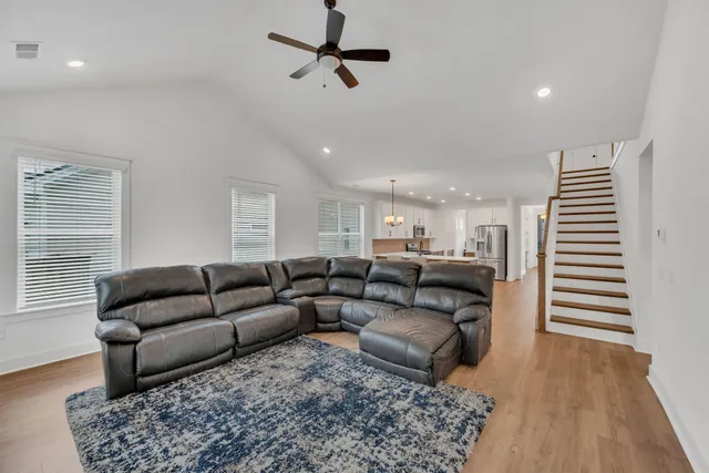 a living room with furniture and a wooden floor