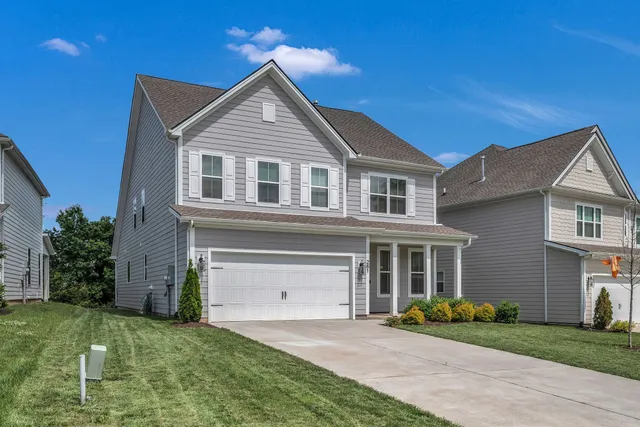 a front view of a house with a yard and garage