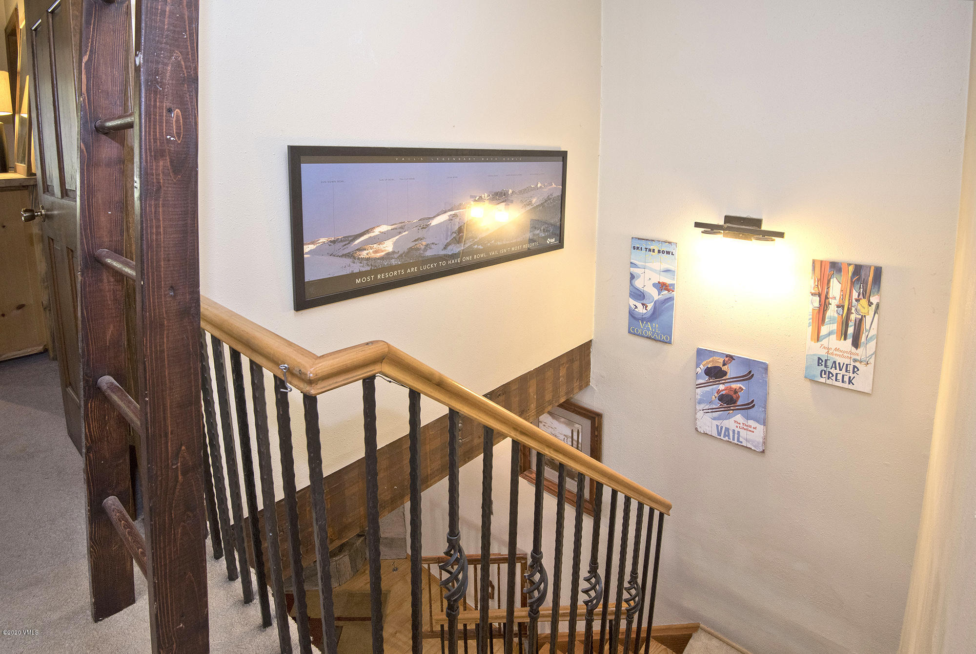 34 Beaver Road, Unit B Avon, CO 81620 - Photo 13 of 34 a view of staircase with lots of frames on wall