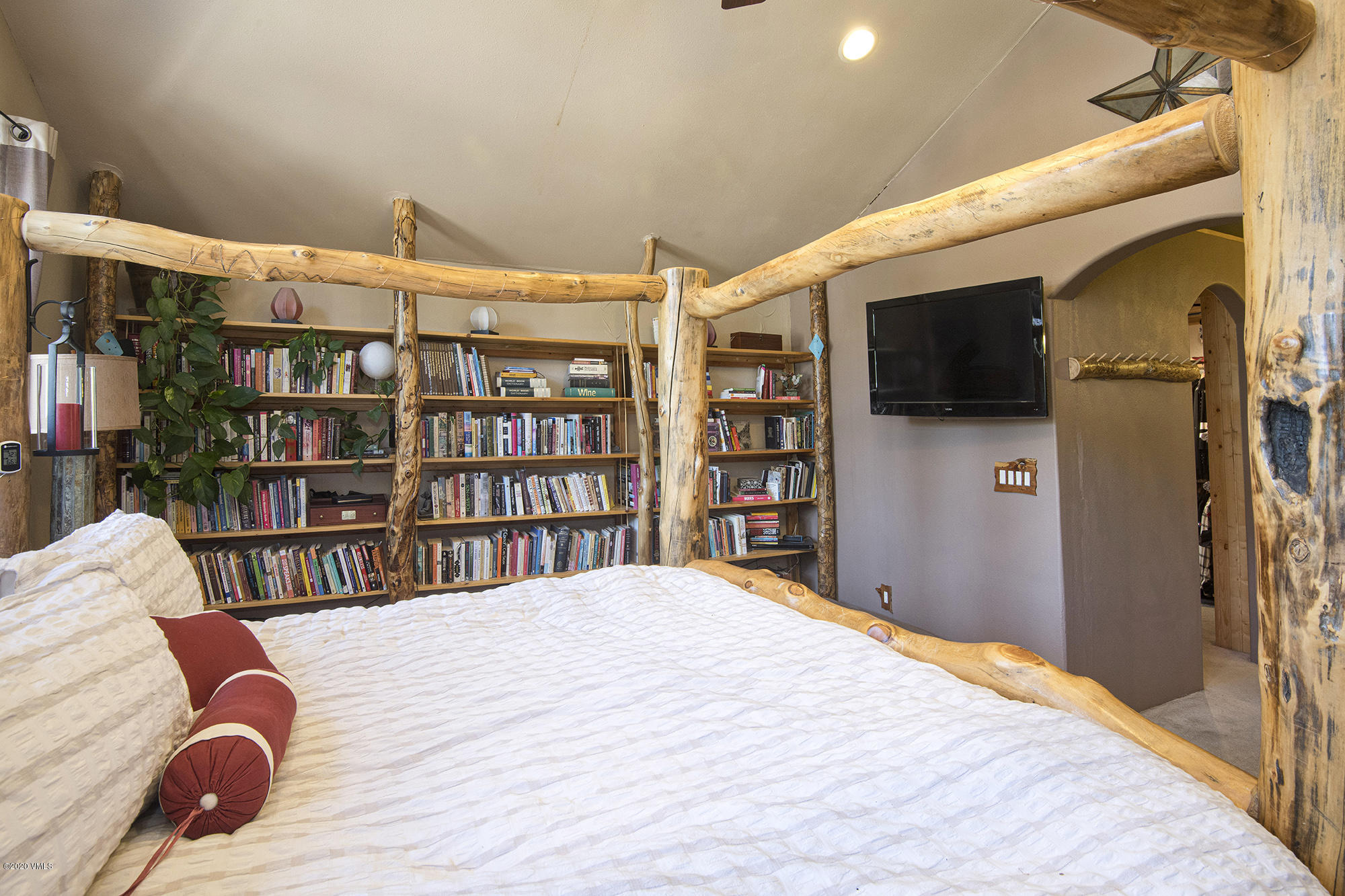 34 Beaver Road, Unit B Avon, CO 81620 - Photo 19 of 34 a bedroom with a bed a flat screen tv and a book shelf