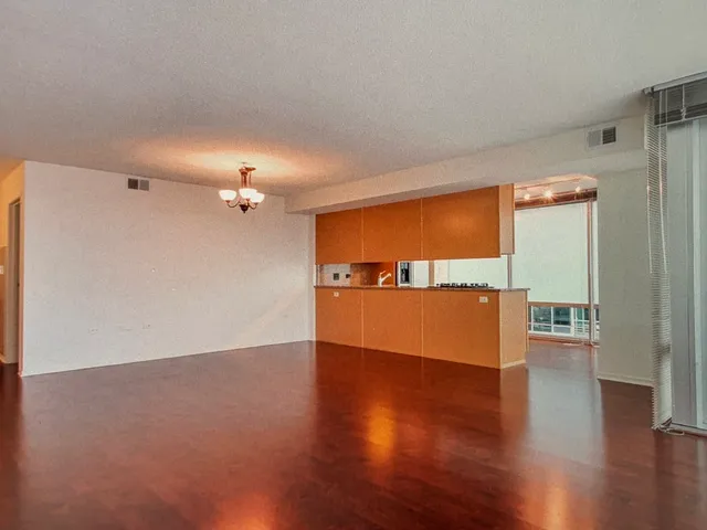 a view of empty room with wooden floor and windows