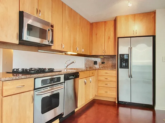 a kitchen with stainless steel appliances a stove a microwave and a refrigerator