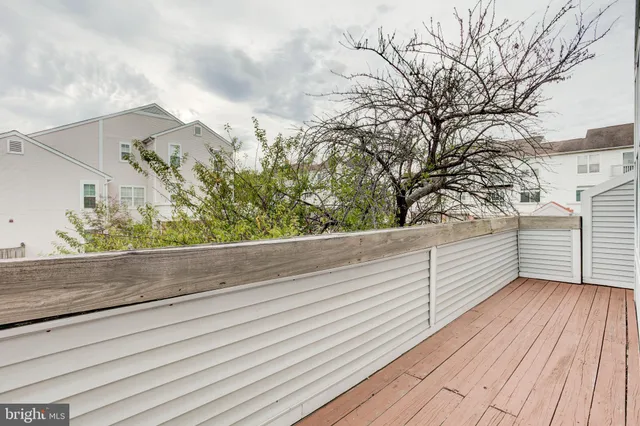 a view of a balcony with wooden floor and fence