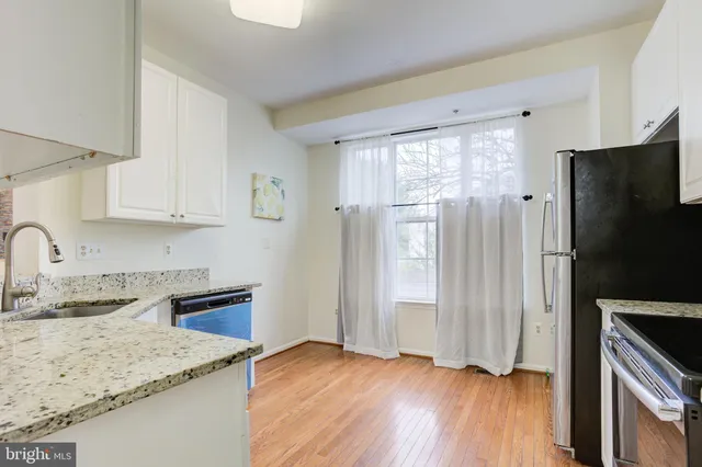 a kitchen with granite countertop a refrigerator sink and stove