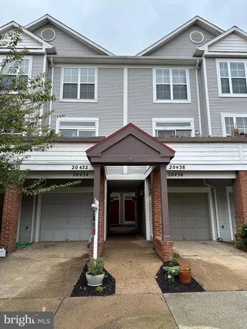 a front view of a house with a garage and a yard