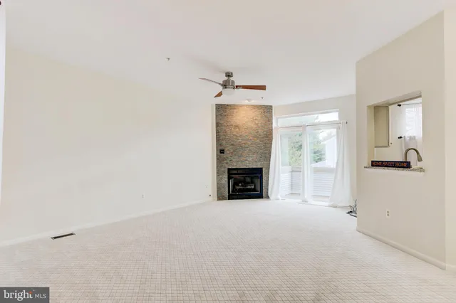 a view of an empty room with a fireplace and a window