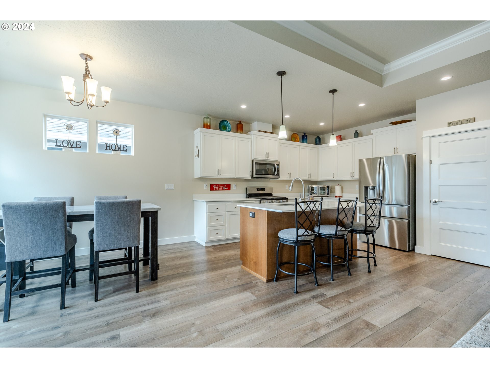 1044 West Olympic Street Springfield, OR 97477 - Photo 11 of 37 a open dining room kitchen with stainless steel appliances kitchen island granite countertop a table chairs and a refrigerator
