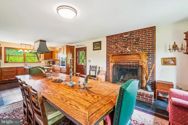 a dining room with furniture a fireplace and wooden floor