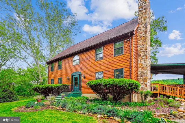 a front view of a house with a yard and potted plants