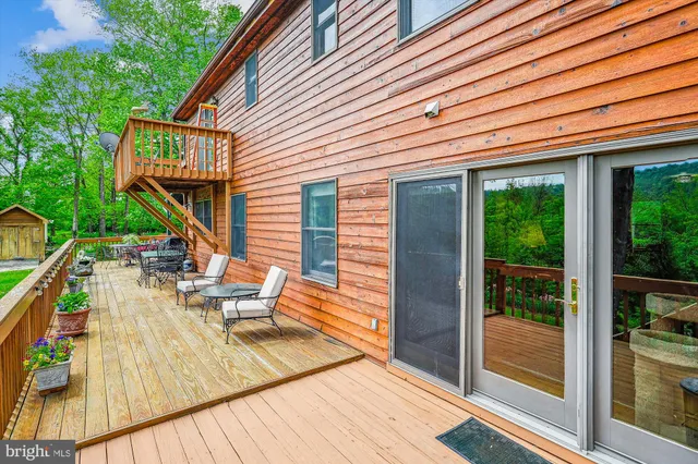a balcony with wooden floor and outdoor seating