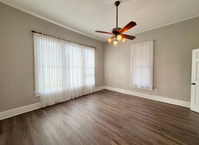 a view of room with wooden floor and windows