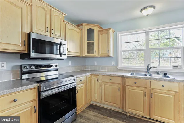 a kitchen with cabinets stainless steel appliances and a window
