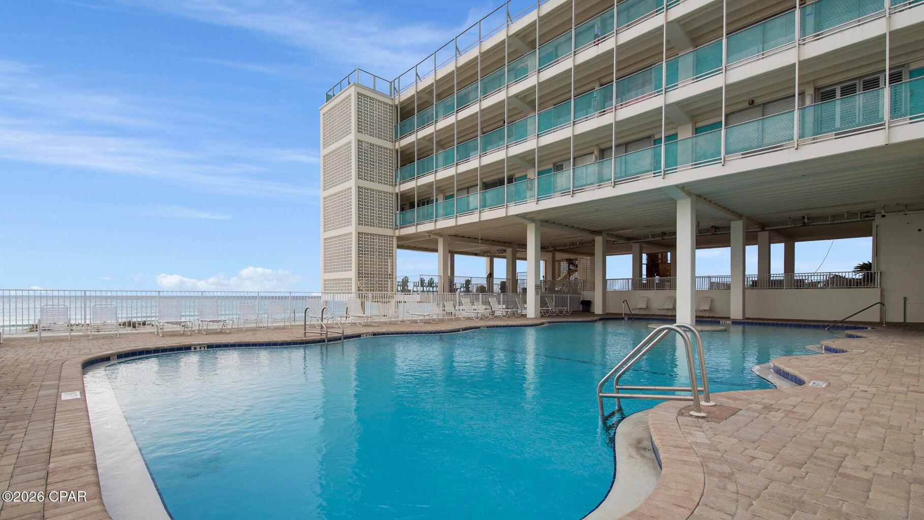14401 Front Beach Road, Unit 221 Panama City Beach, FL 32413 - Photo 18 of 20 a view of a swimming pool with a lounge chairs