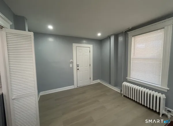 a view of an empty room with wooden floor