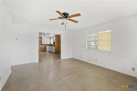 a view of a livingroom with a ceiling fan and window