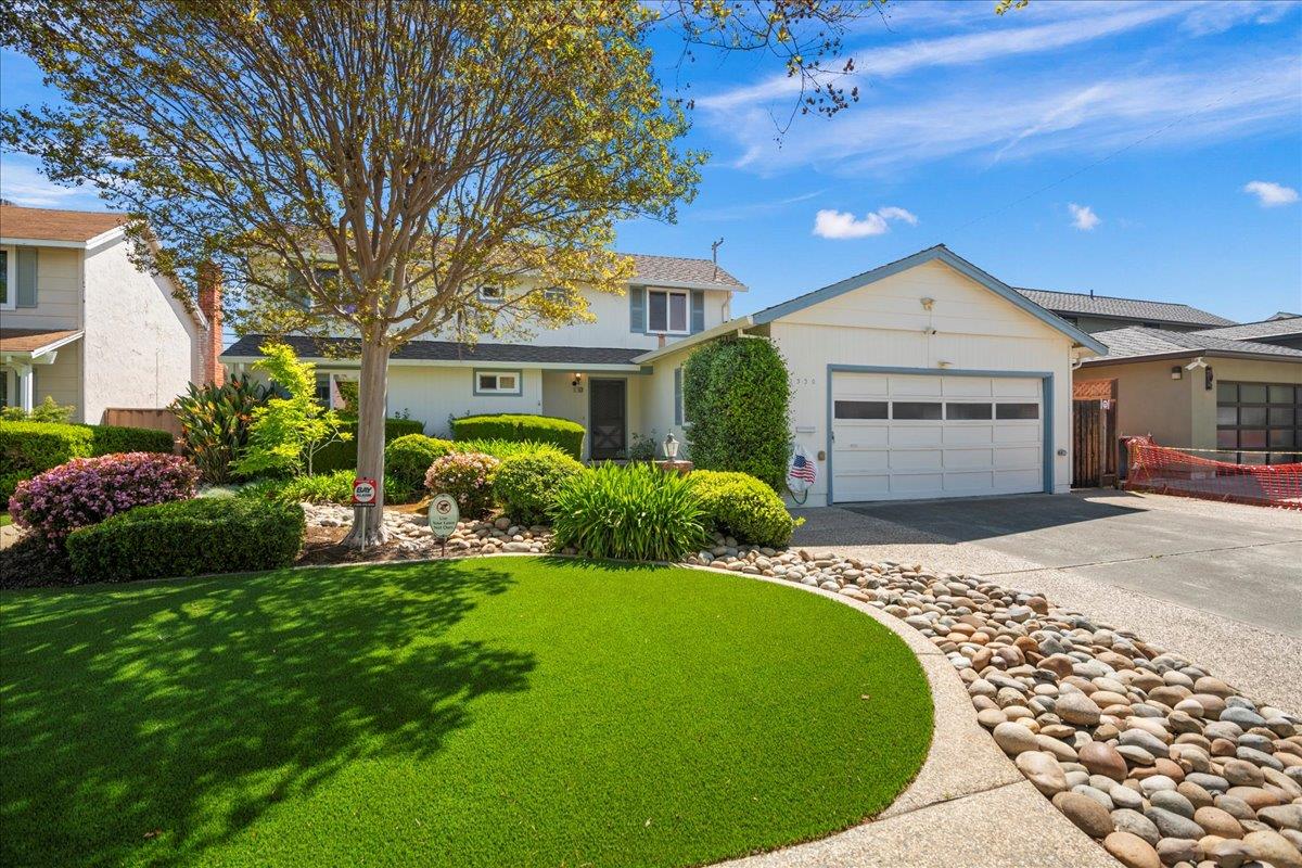 a front view of a house with a garden and plants
