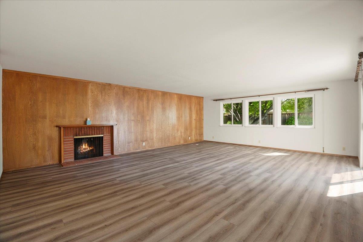 2330 Montezuma Drive Campbell, CA 95008 - Photo 3 of 19 an empty room with windows fireplace and wooden floor
