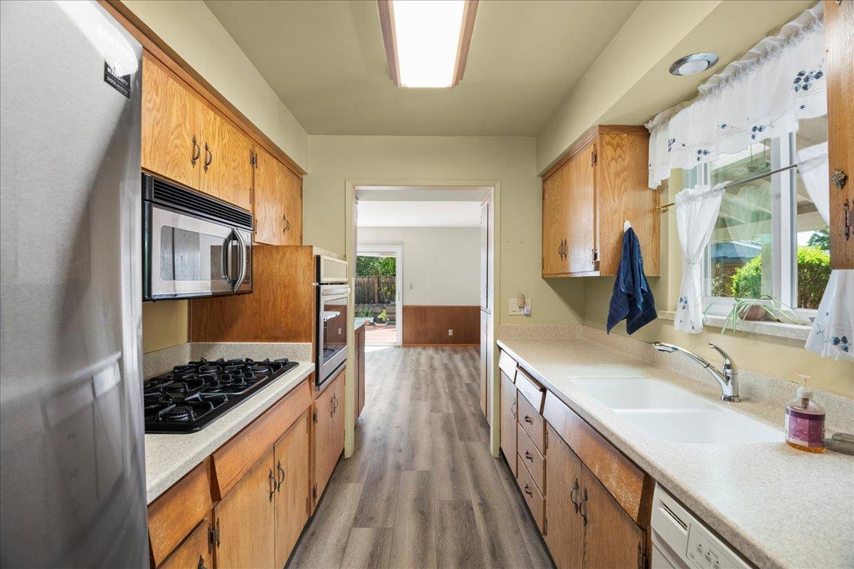 2330 Montezuma Drive Campbell, CA 95008 - Photo 6 of 19 a kitchen with stainless steel appliances kitchen island granite countertop a sink stove and wooden cabinets