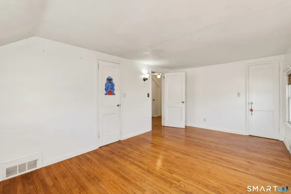 a view of a room with wooden floor and white walls