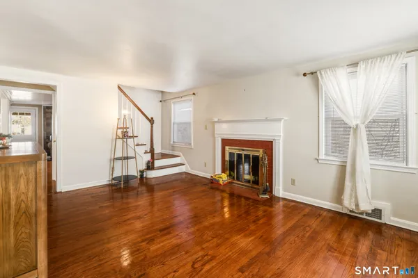 a view of a livingroom with wooden floor and a fireplace