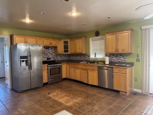 a kitchen with granite countertop a refrigerator oven a sink a counter space and cabinets