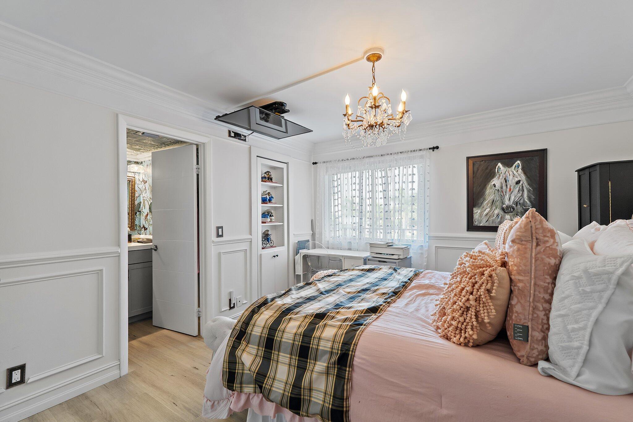 1605 Highway 1, Unit F202 Jupiter, FL 33477 - Photo 21 of 33 a bedroom with a large bed and a chandelier