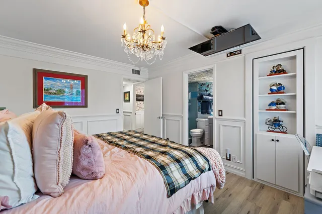 a bedroom with a bed and a chandelier