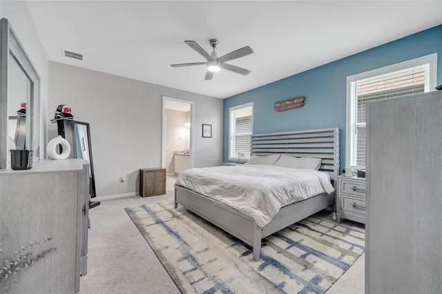 a bedroom with a large bed and a chandelier
