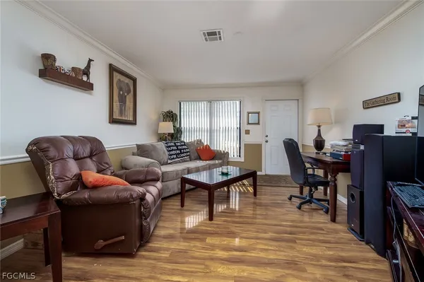 a living room with furniture a flat screen tv and a table