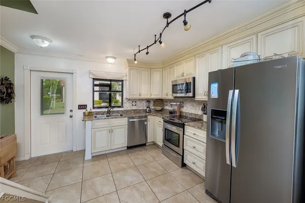 a kitchen with stainless steel appliances granite countertop a refrigerator oven a sink dishwasher and a refrigerator