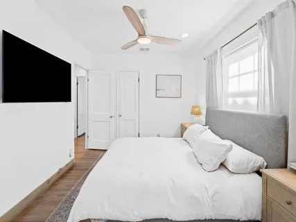 a bedroom with a bed and a flat screen tv