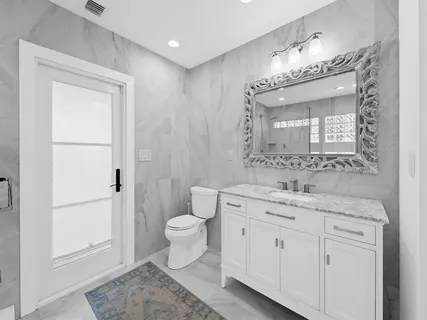 a spacious bathroom with a toilet sink and mirror