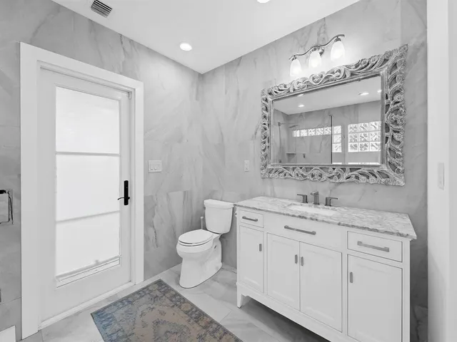 a spacious bathroom with a toilet sink and mirror
