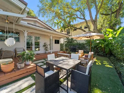 a view of a patio with a dining table and chairs with wooden floor and fence