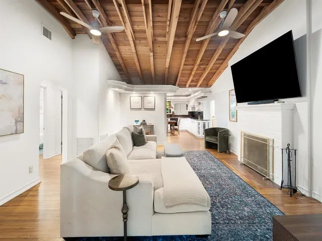 a living room with furniture a flat screen tv and a fireplace