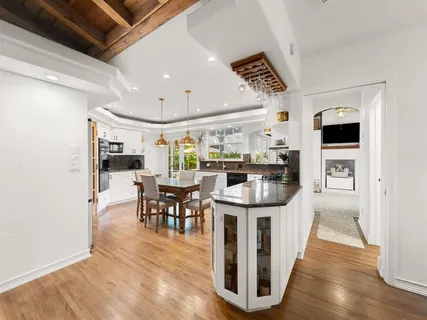 a kitchen with stainless steel appliances kitchen island granite countertop a table chairs and a refrigerator
