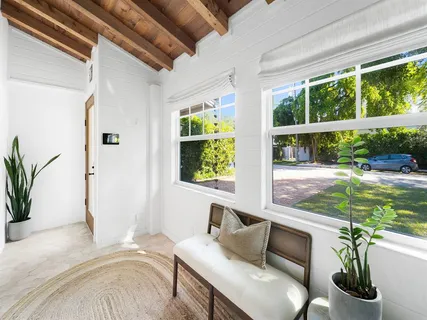 a bedroom with furniture and a large window