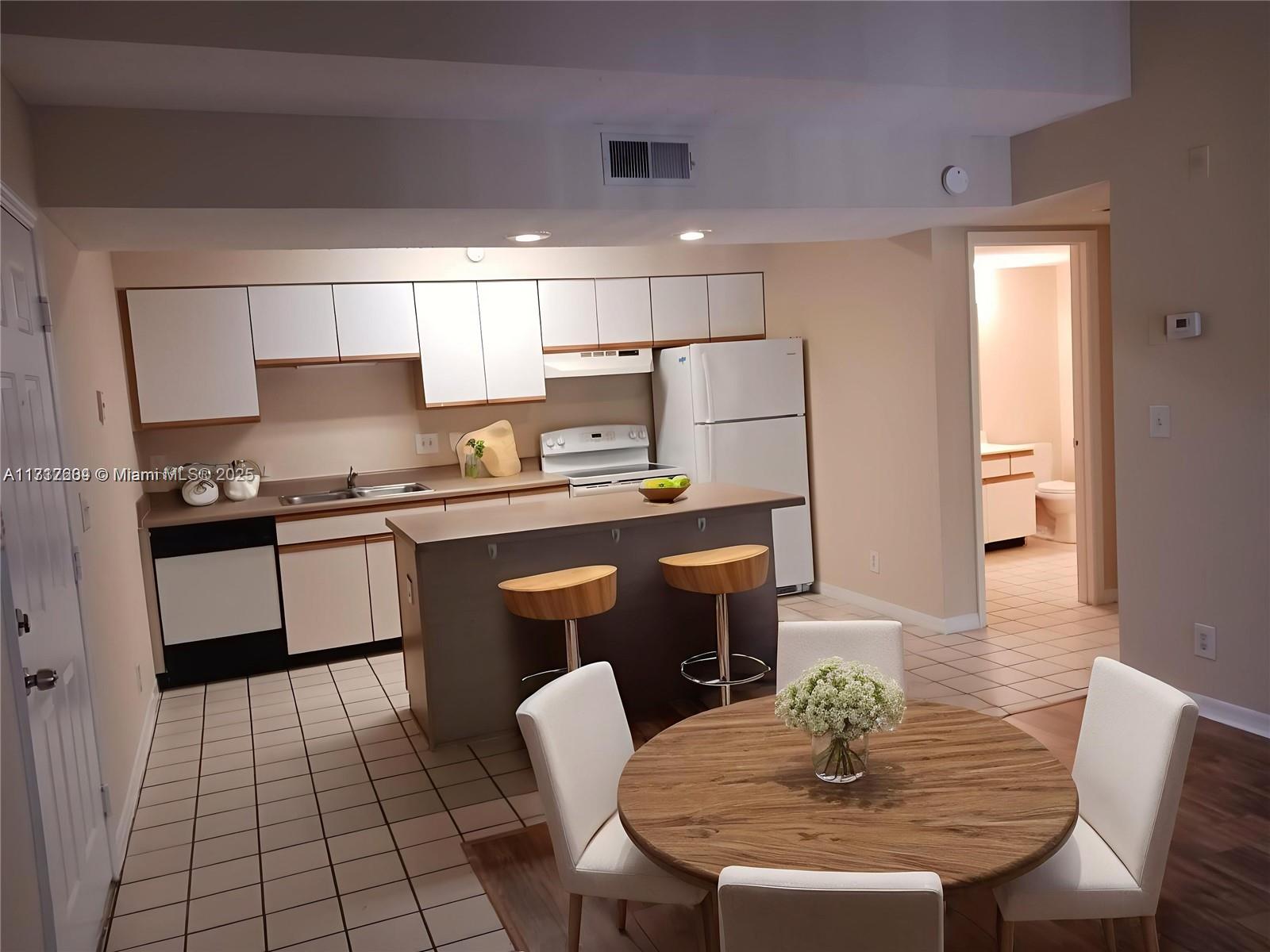 Palm Aire Pompano Beach, FL 33069 - Photo 7 of 11 a kitchen with stainless steel appliances granite countertop a sink a stove a refrigerator a dining table and chairs